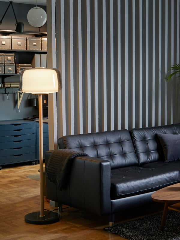 Divano a 3 posti LANDSKRONA in fior di pelle, un plaid grigio scuro e una lampada da terra in una casa dai colori coordinati - IKEA