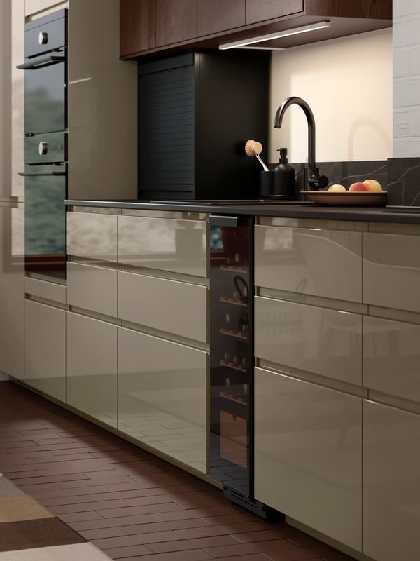 A black TITTEBO tambour storage for smaller appliances is standing on a kitchen worktop and the tambour door is open.