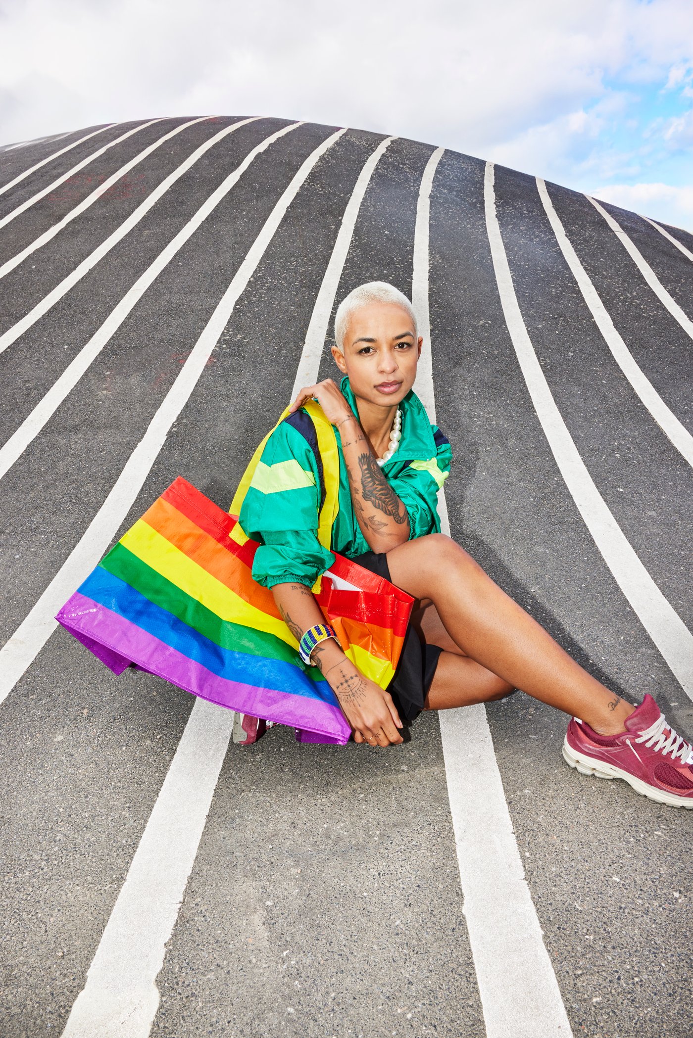 A lady carrying a STORSTOMMA rainbow bag