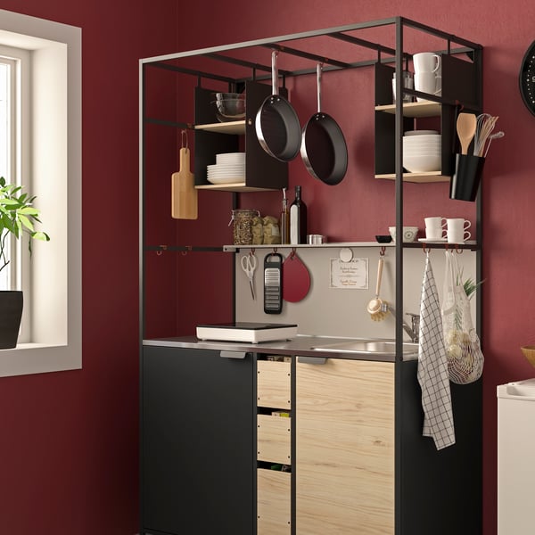 A black/ash ÄSPINGE kitchenette against a red wall.