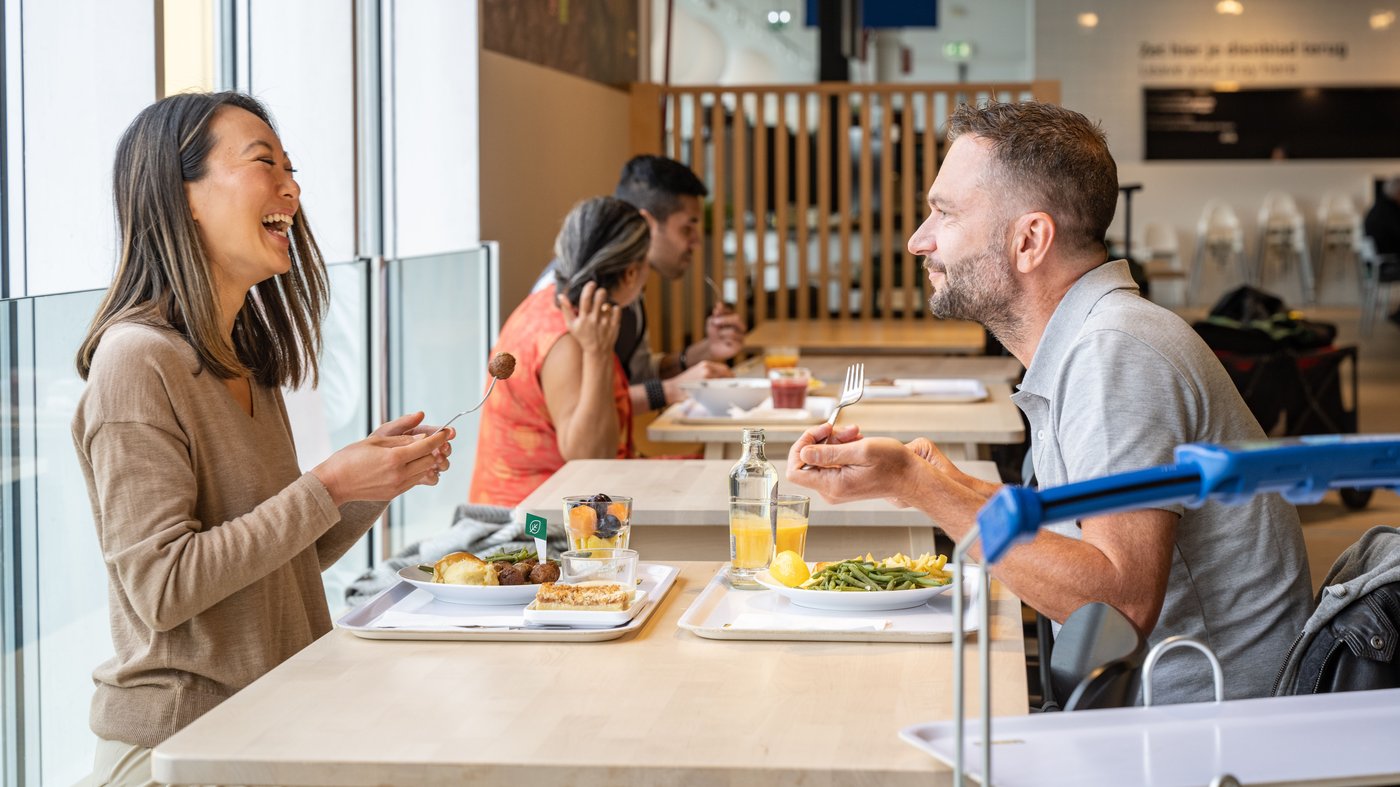 Personas almorzando y disfrutando los platos de IKEA en su restaurante.