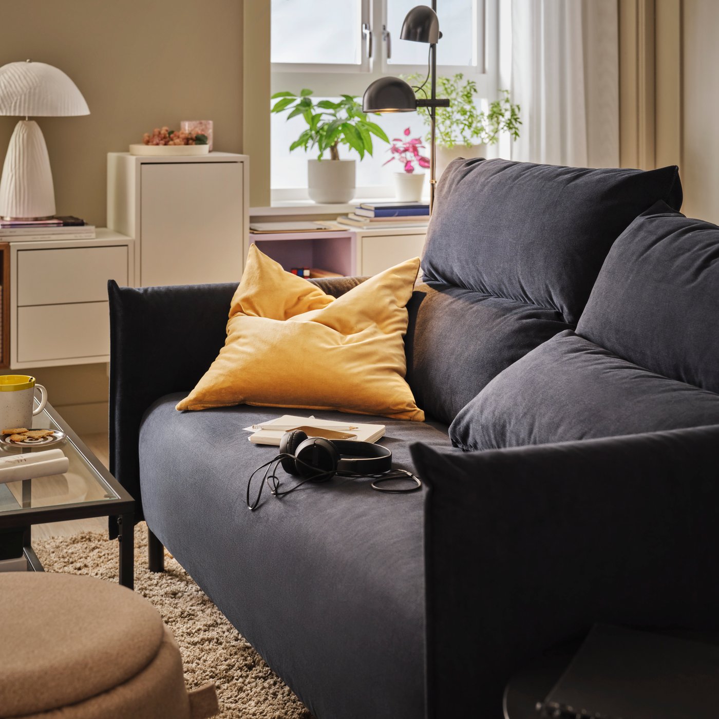 Ein schwarzblaues MANNARP 2er-Sofa in einem Wohnzimmer