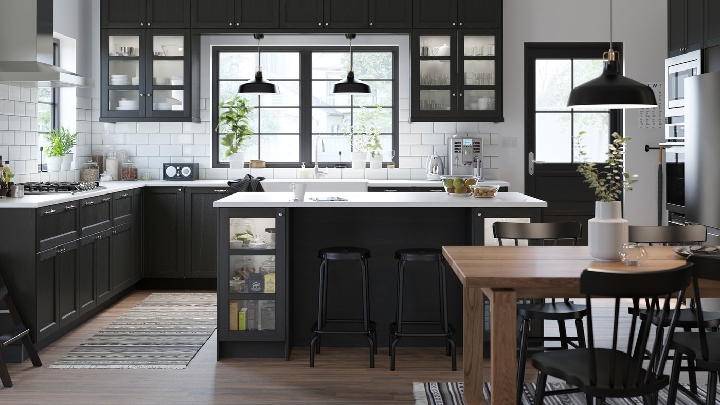 an IKEA METOD kitchen with a kitchen island, RANARP black pendant lights and NORRARYD black chair