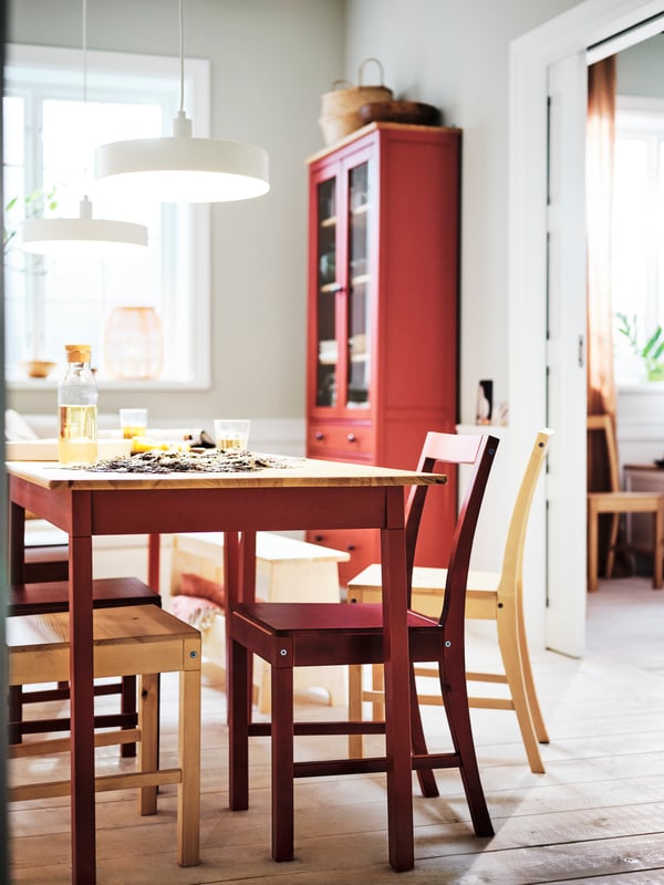 A light brown stained PINNTORP chair at a red painted PINNTORP table.