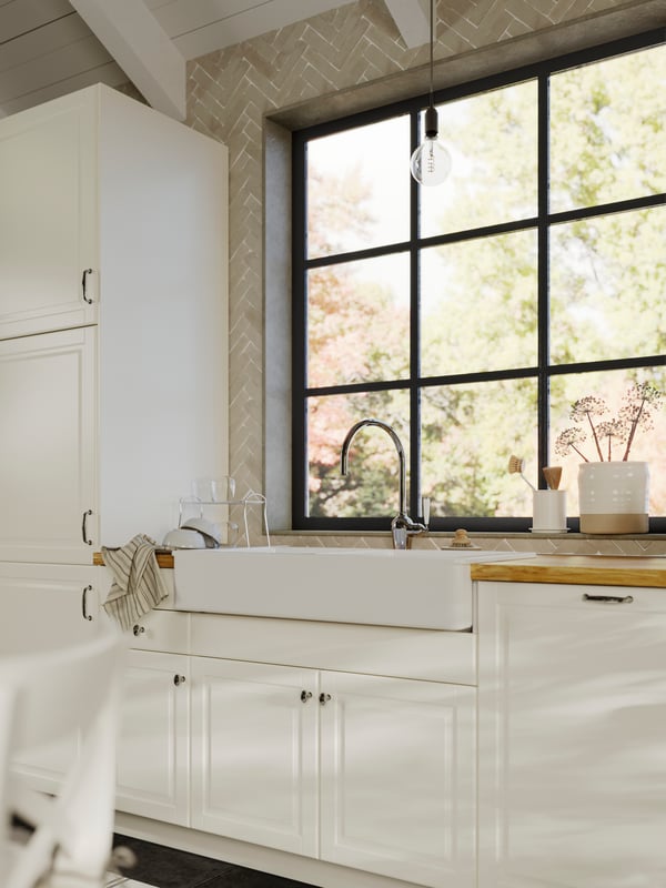 A kitchen with a HAVSEN sink bowl in white, BODBYN doors in off-white, a KARLBY worktop in oak/veneer and a kitchen window.