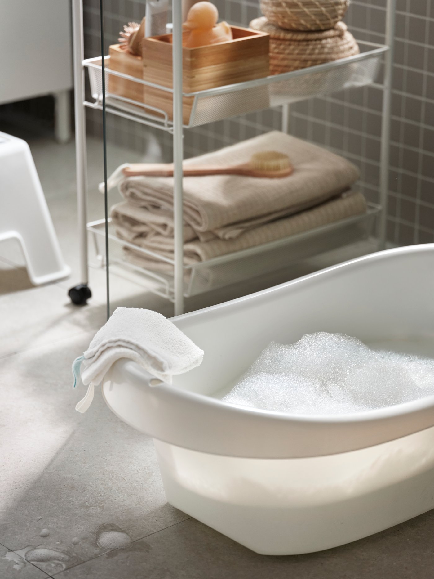 A white/green LÄTTSAM baby bath in the bathroom