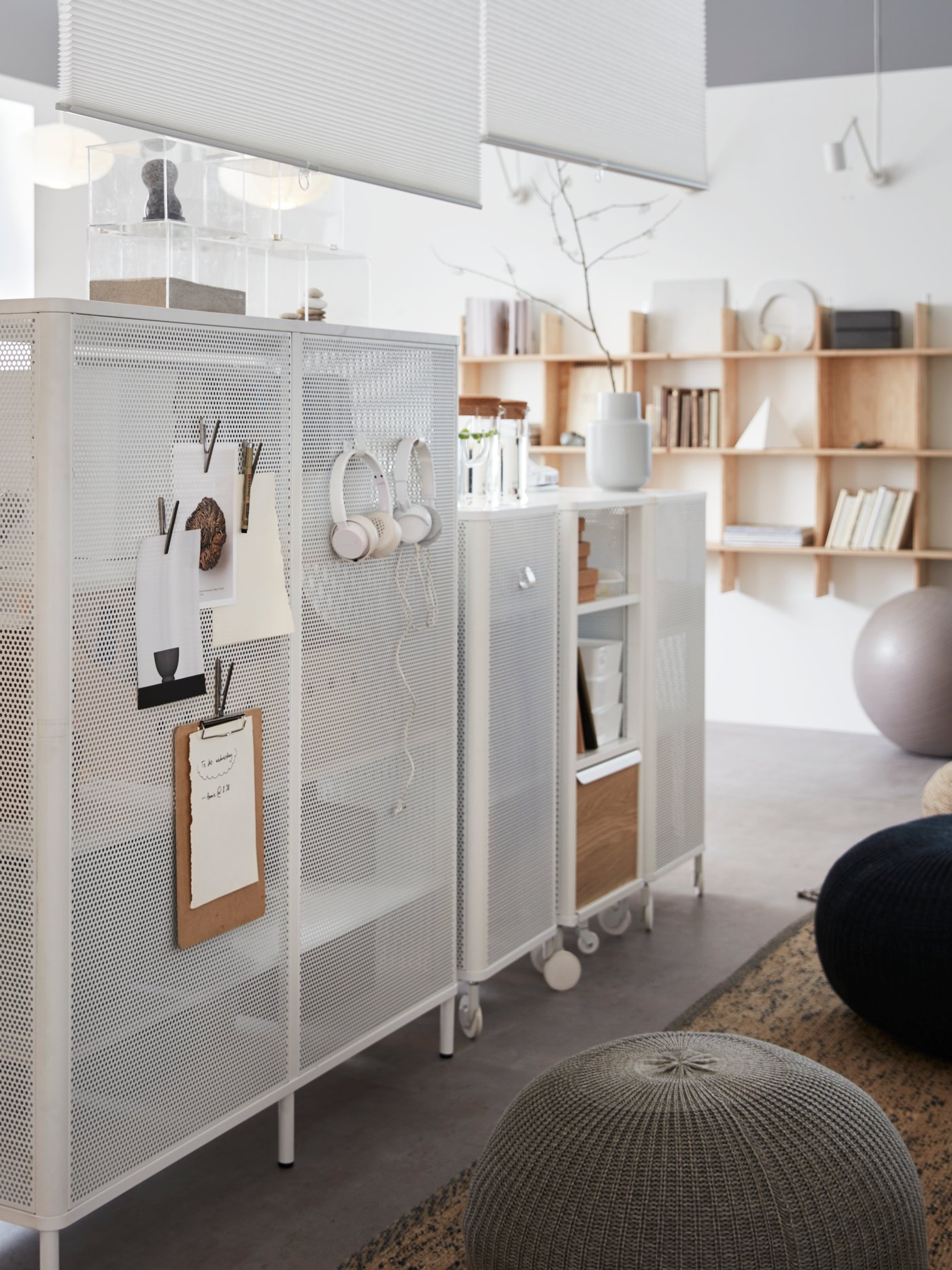 A row of BEKANT white mesh shelving units, with magnetic sides for clips and hooks, wooden shelving on the far wall.