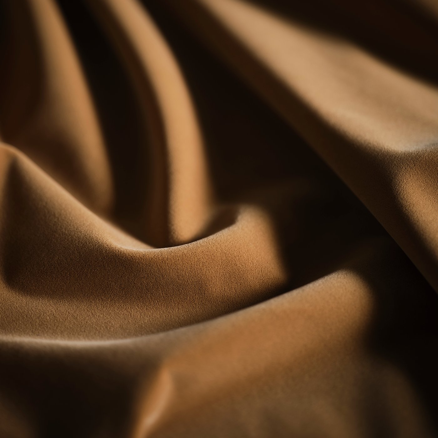 A close-up of the beige cover of a STOCKHOLM 2025 pouffe, arranged in a way that it folds softly, creating gentle waves.