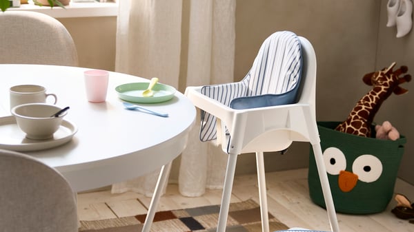 Une chaise haute ANTILOP blanche avec ceinture de sécurité dans la salle à manger