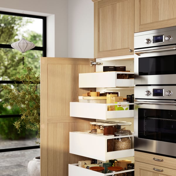 Cajones de cocina MAXIMERA blancos con distintos frascos de vidrio con aliños y condimentos.