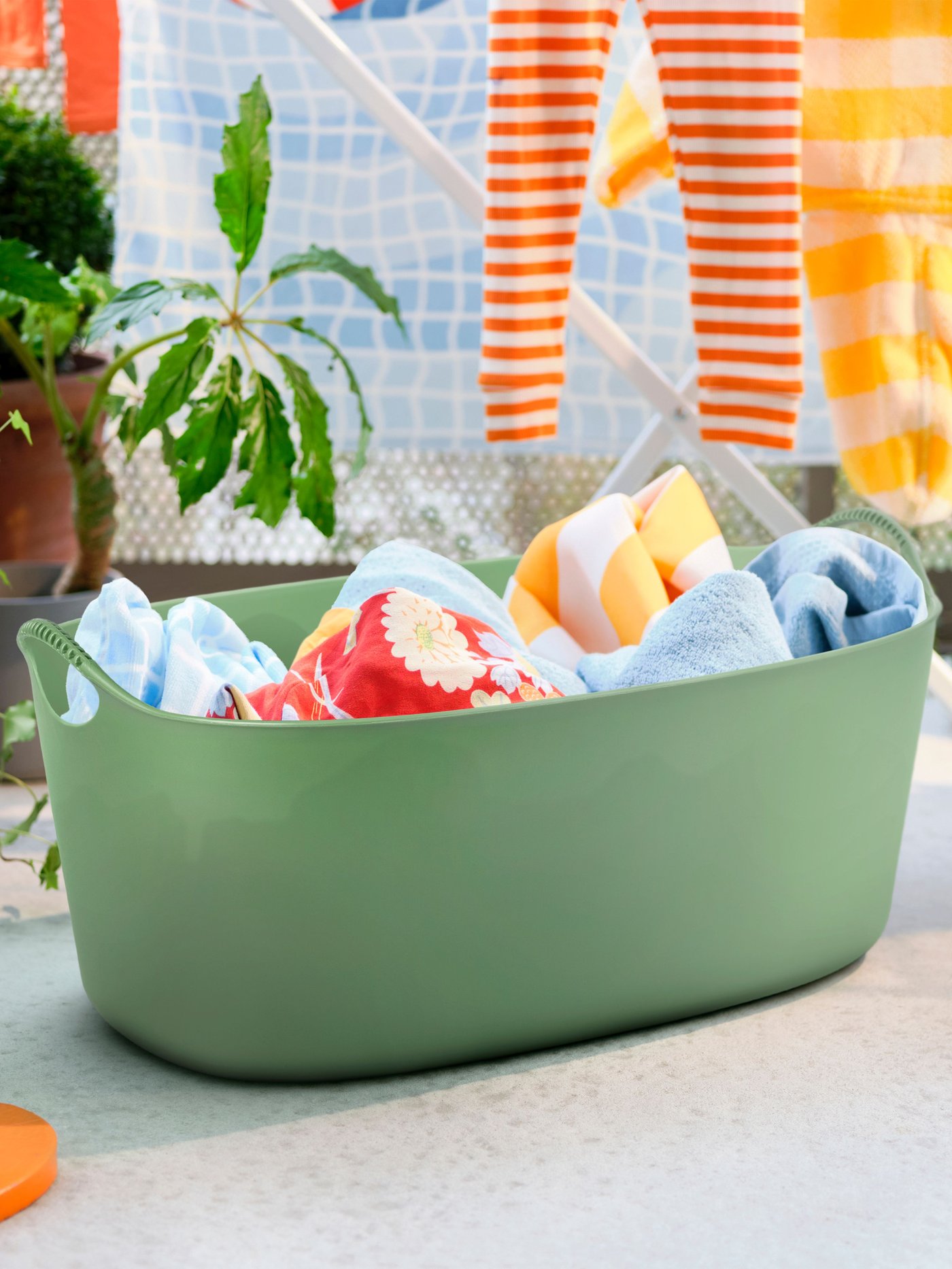 A green TORKIS flexi laundry basket, in-/outdoor outside