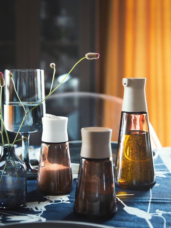 Differnet sizes of HALVTOM bottles on a dining table with OBMONAD wine glass.