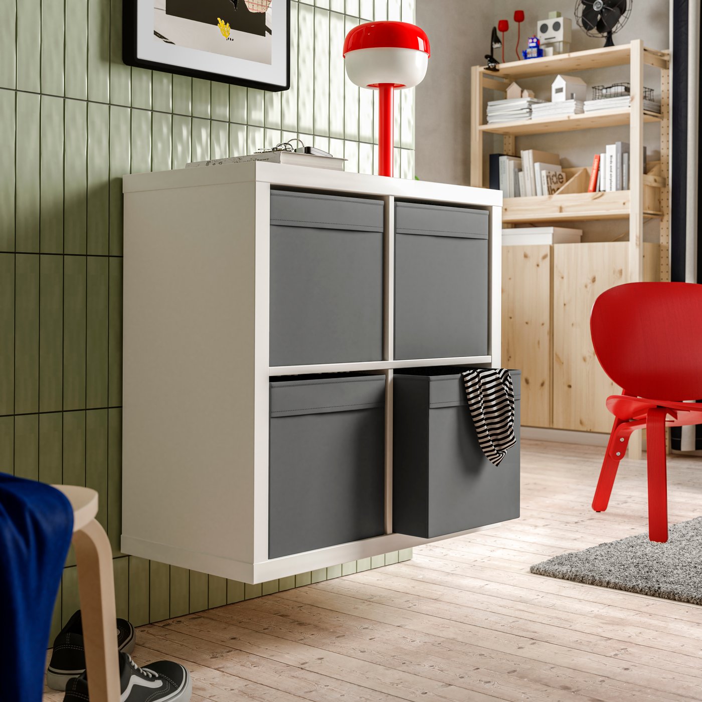 A wall section with a wall-mounted white KALLAX shelving unit with a dark-grey DRÖNA box in each of its four compartments.