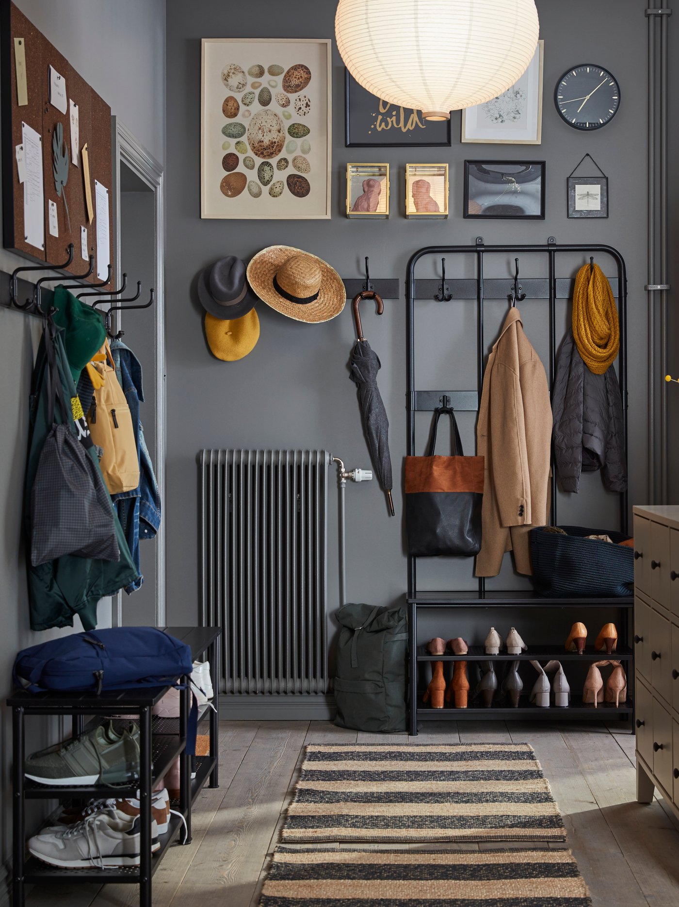 Entrée grise avec manteaux et chaussures bien rangés et tapis de couloir