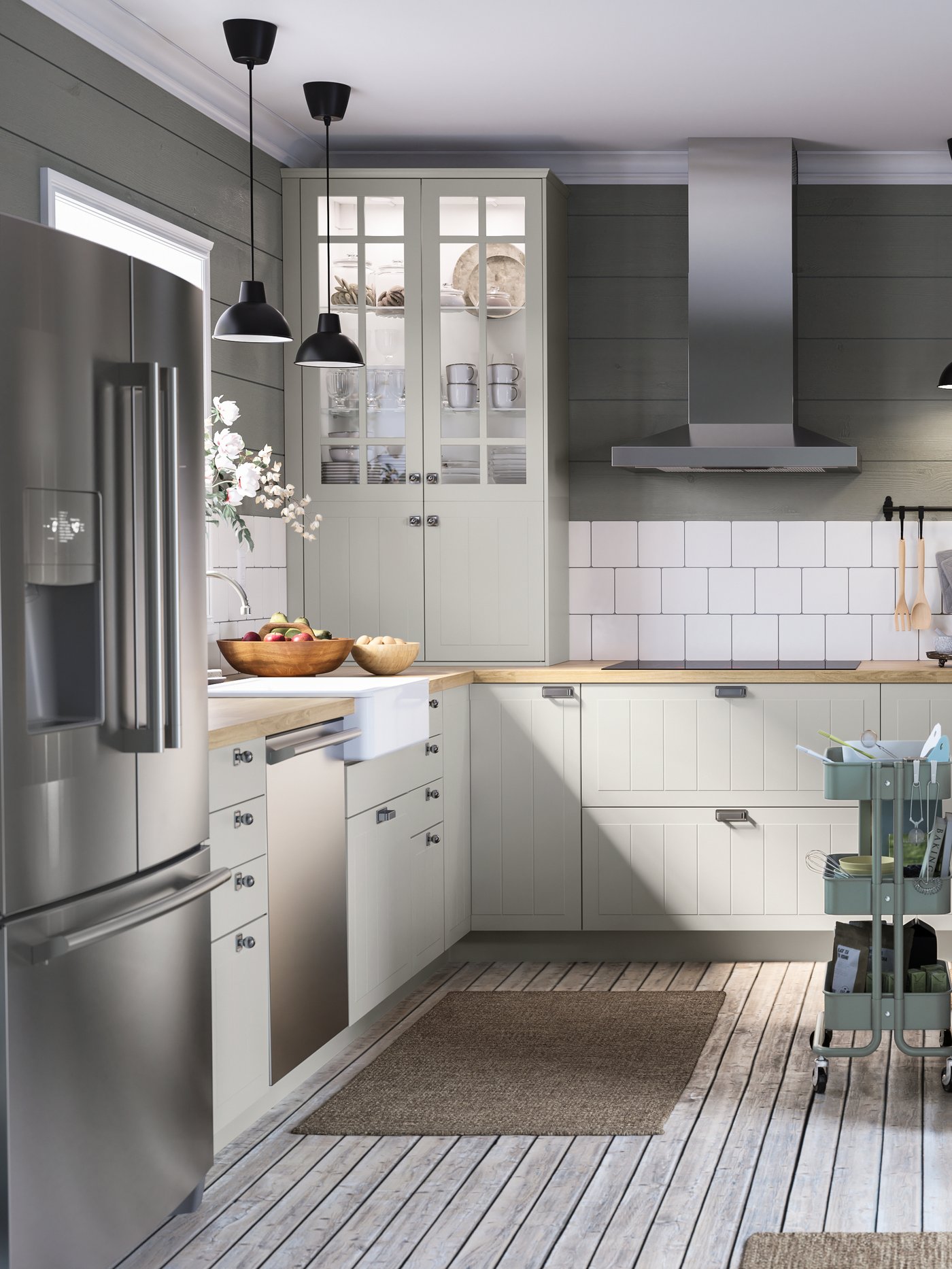 A large kitchen with green and white walls, a kitchen island with bakeware, black rails with hooks, a cart.
