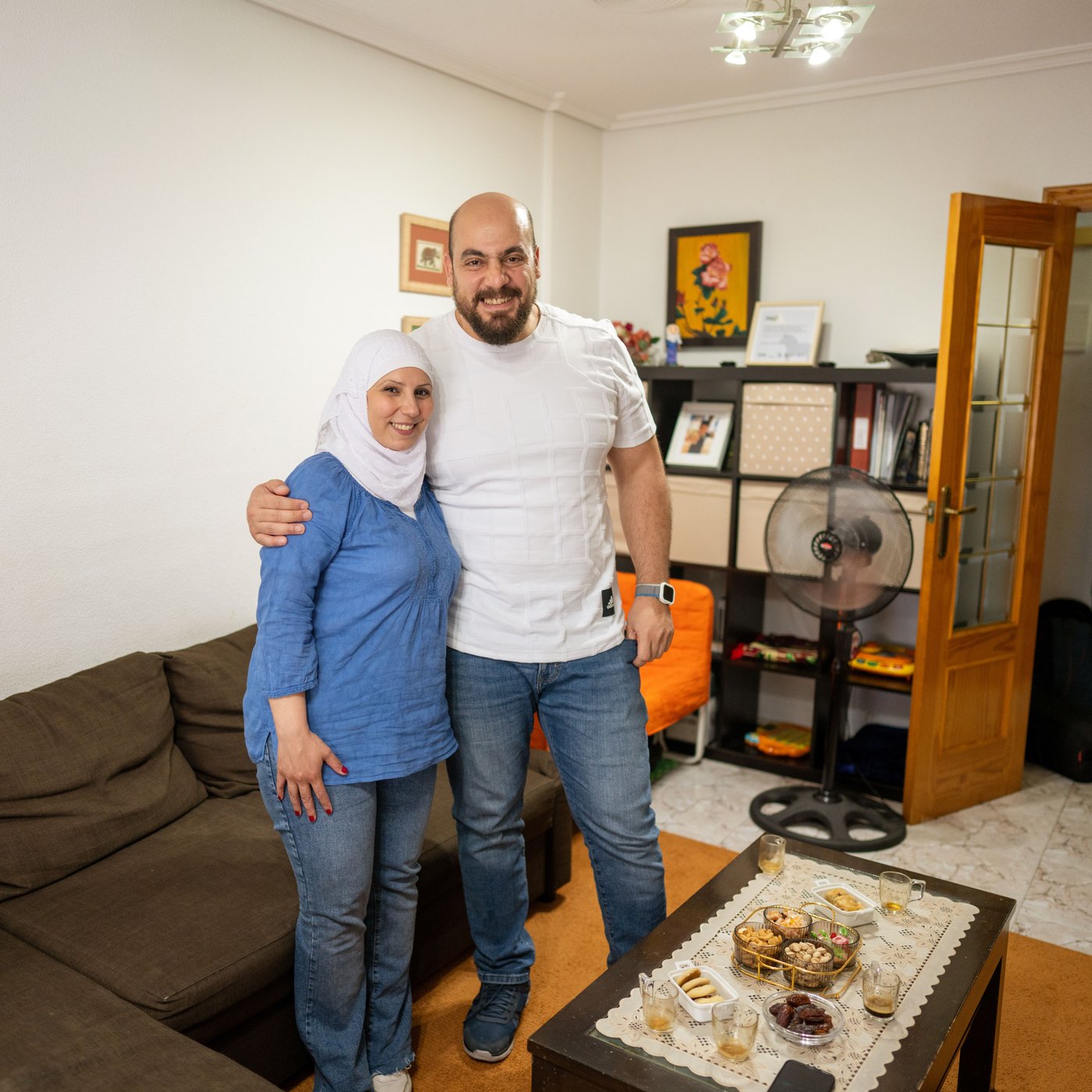 Zahra i Tarek stoje u dnevnoj sobi, zagrljeni su i osmehuju se pred kamerom pre pauze za kafu.