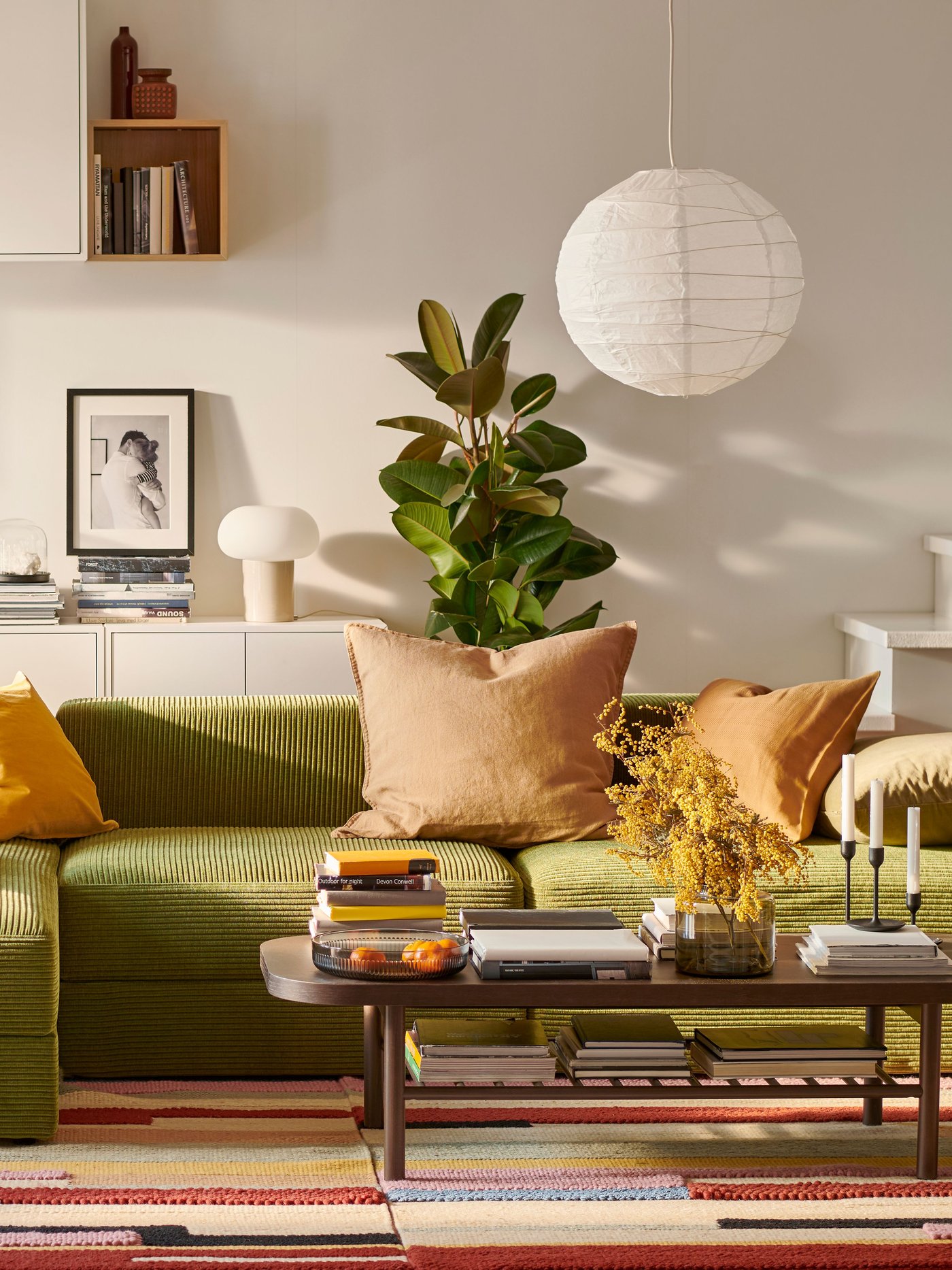 A JÄTTEBO sofa with chaise longue and a LISTERBY coffee table stand on a colorful BRÖNDEN carpet in a living room.