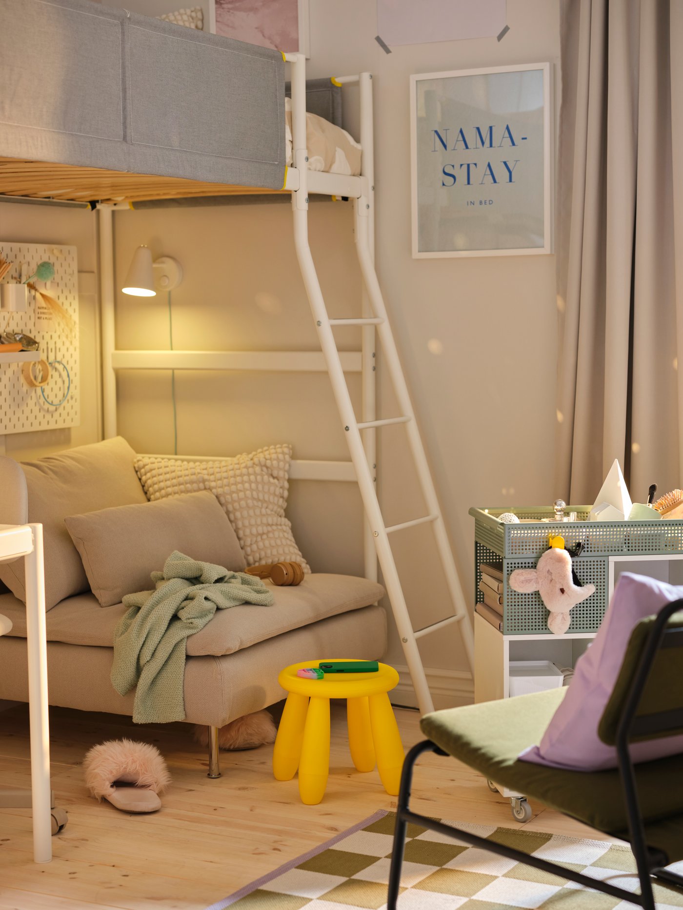Un dormitorio infantil con una cama alta VITVAL que debajo tiene un sofá infantil y un escritorio.