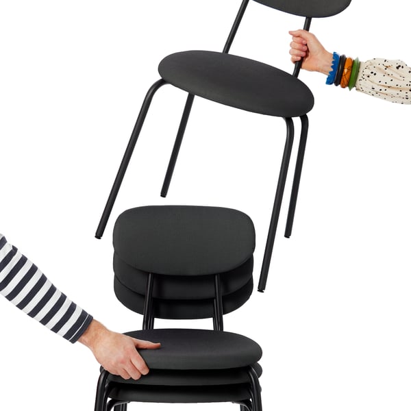 People reach to pick up black ÖSTANÖ chairs from a stack.