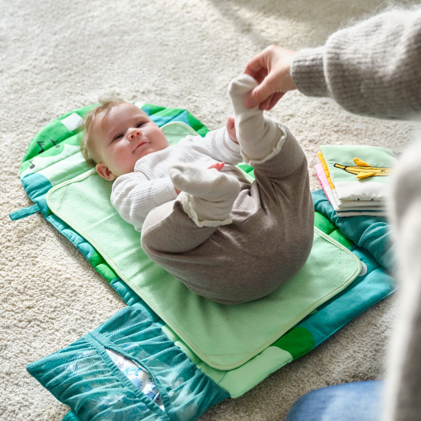 A foldable/green GRÖNFINK babycare mat