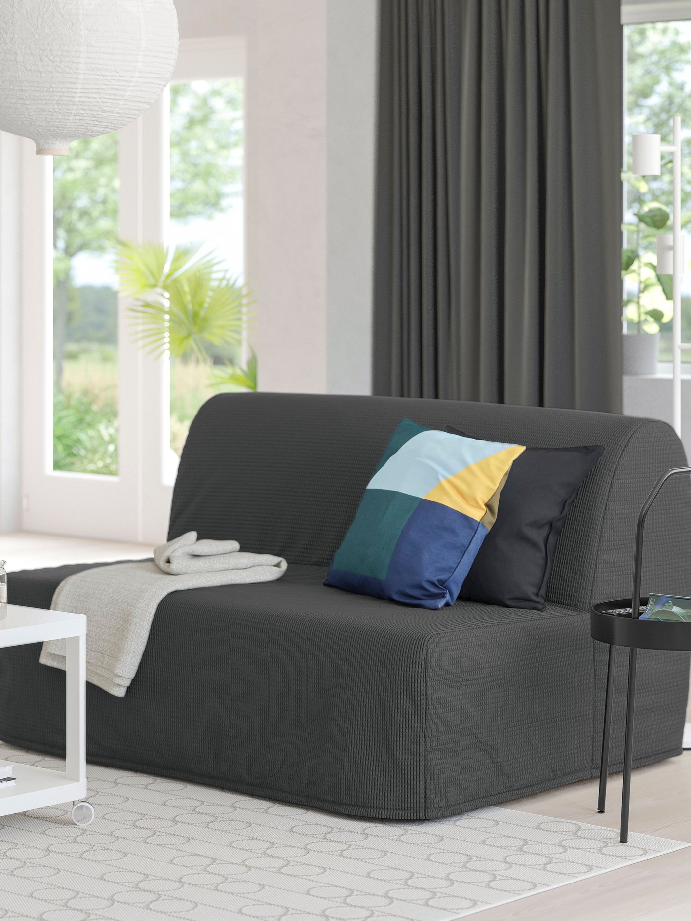 A Vansbro dark grey LYCKSELE MURBO 2-seat sofa-bed in the living room