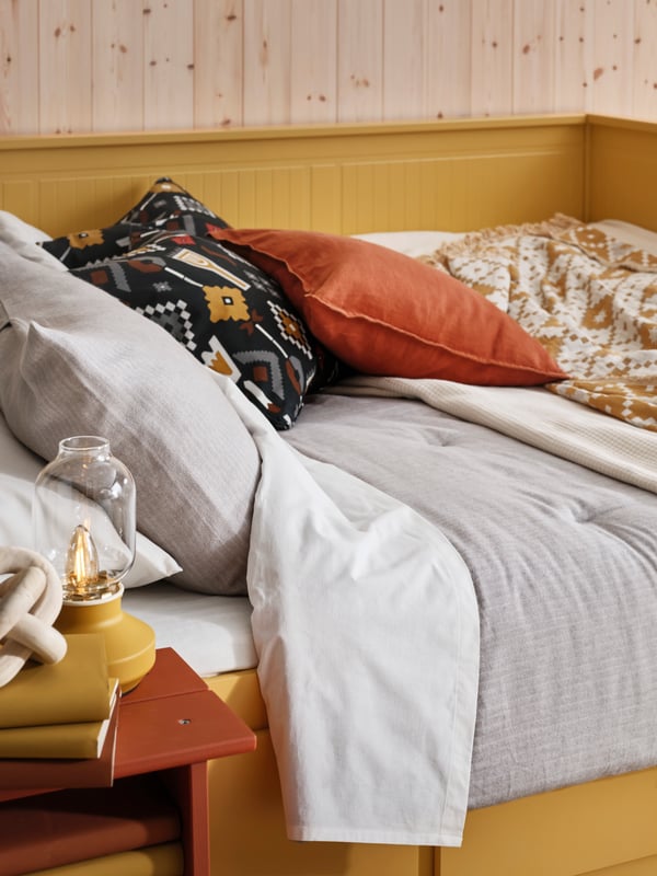 Close up of a HEMNES day-bed dressed with an ORMÄNGSFLY duvet cover, MOSSNYNYCKLAR and ÄNGSLILJA cushions.