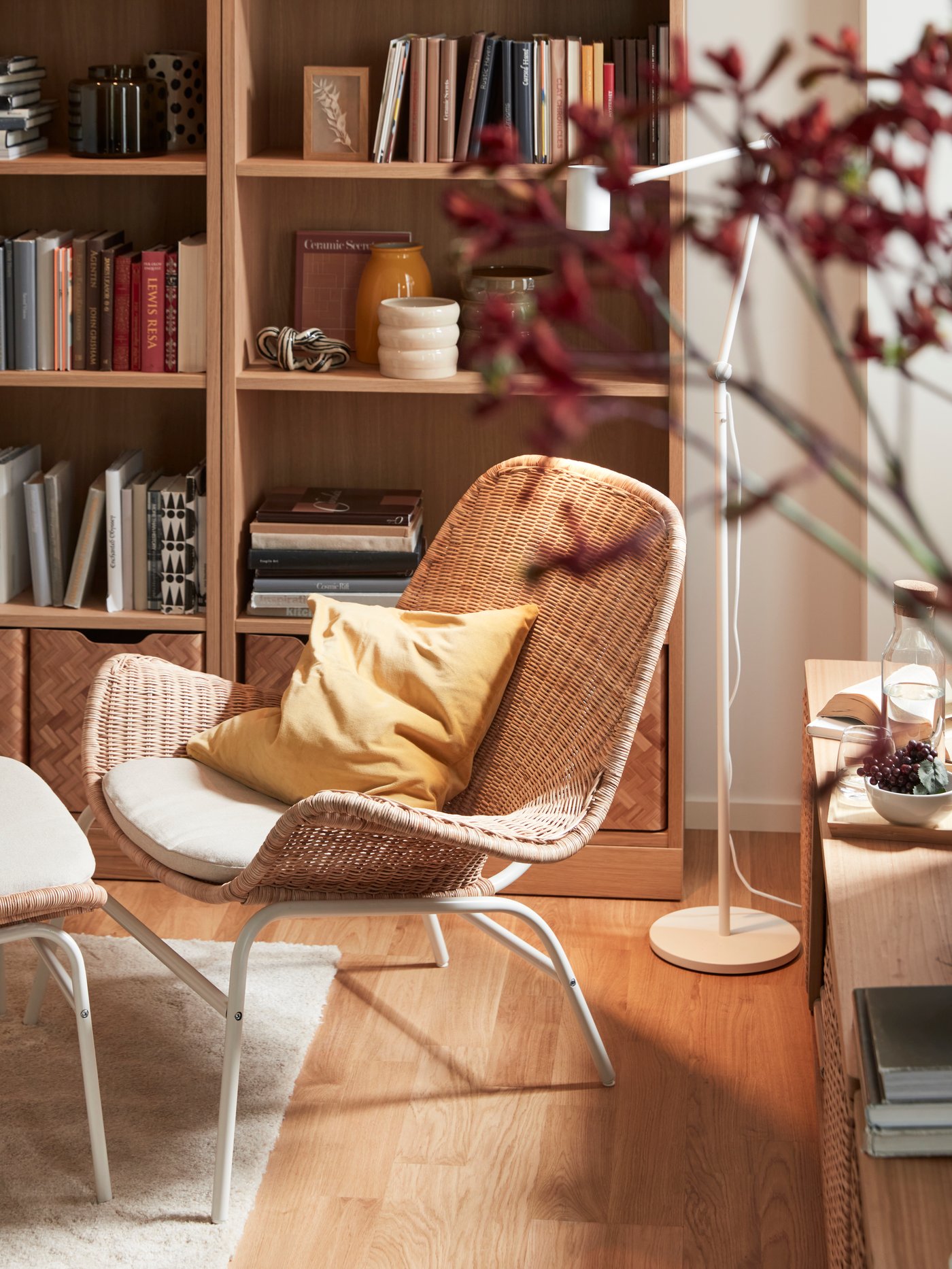 A rattan/Risane natural FRYKSÅS armchair with cushion in the living room