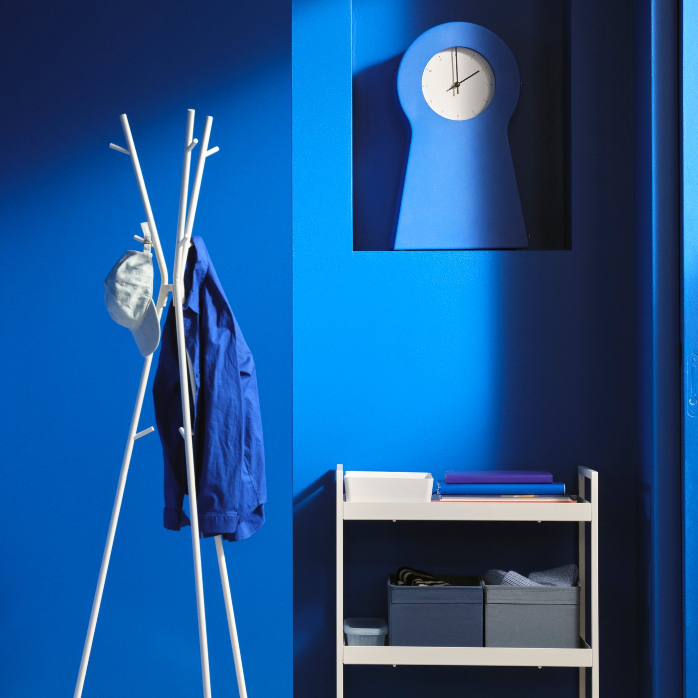 Une horloge bleue IKEA PS 1995 se trouve sur une étagère dans une pièce bleue.