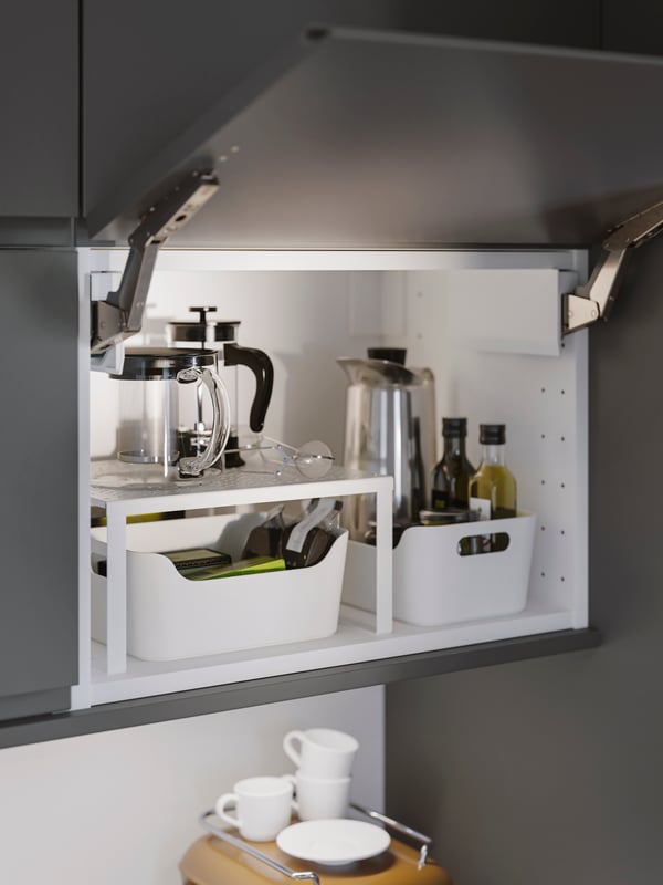 An open kitchen cabinet that is neatly organized with white VARIERA boxes.