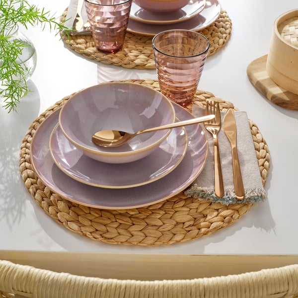 A rose-gold colour FÖRNUFT 24-piece cutlery set in the dining room