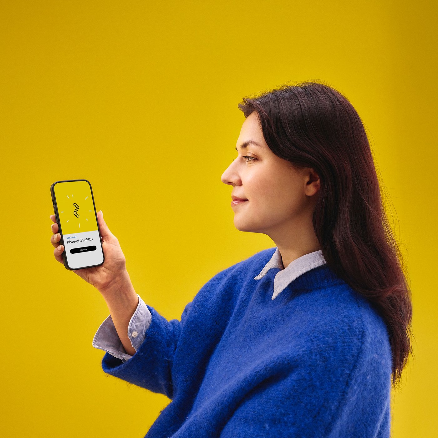 A woman in a blue sweater is holding a mobilephone.