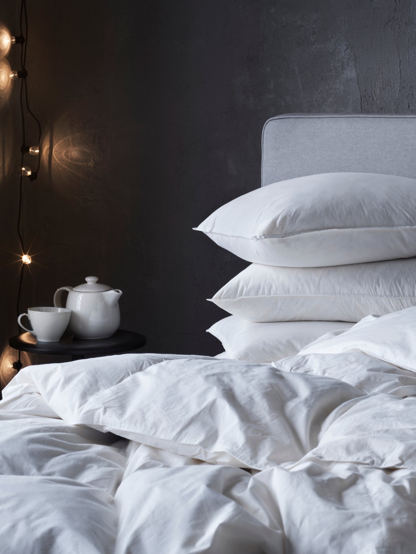 Eine Decke und mehrere Kopfpolster auf einem Bett.