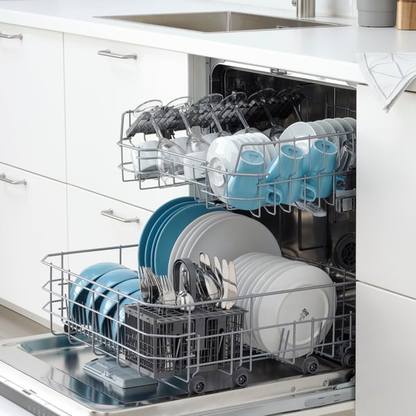 An IKEA 300 RENGÖRA integrated dishwasher open is filled with clean dishes.