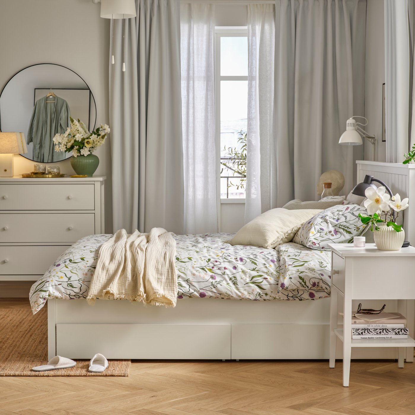 Ein Schlafzimmer mit hellblauer MATTOXBÄR Bettwäsche mit Blumenmuster auf einem GULLABERG Bettgestell.