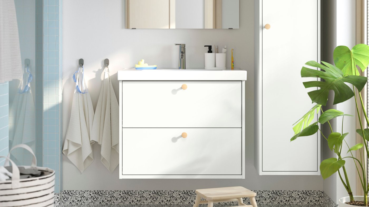 Un meuble pour lavabo HAVBÄCK blanc avec tiroirs, lavabo et robinet