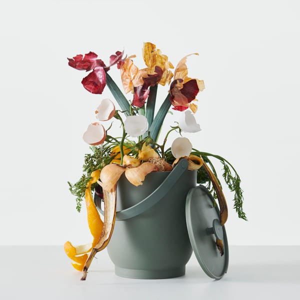 A FARMARKVAST organic waste bin overflowing with fruit and vegetable peels arranged to look like a floral display.