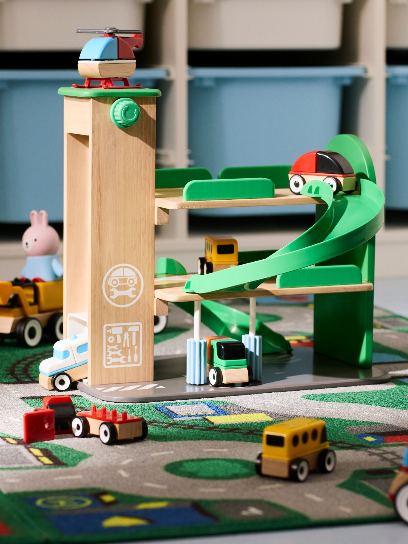 The complete LILLABO garage with helicopter and a lot of toy vehicles rolling around the garage, ramp and rug.