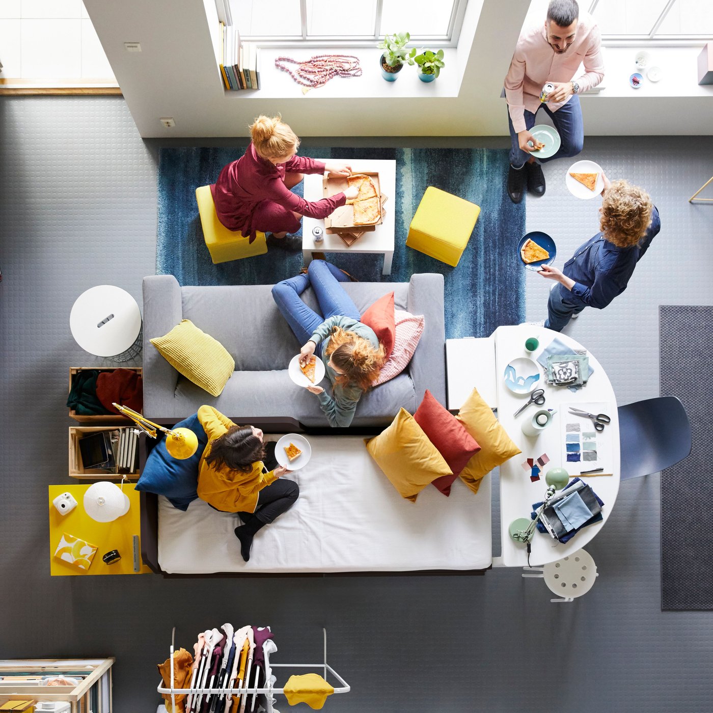From above, you can see a sofa landscape and several people eating and chatting with each other.