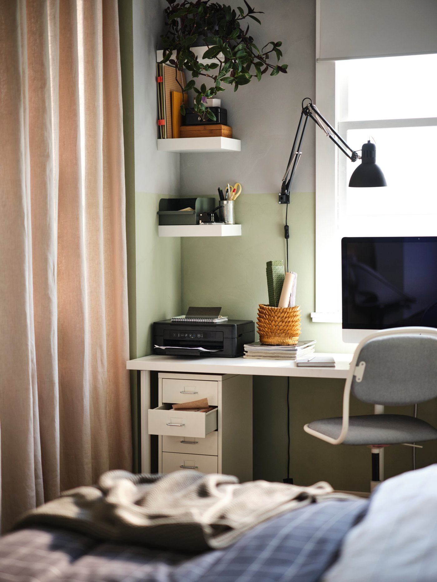 Weiße LACK Wandregale in einer Zimmerecke über einem Schreibtisch mit Monitor und Schreibtischlampe.
