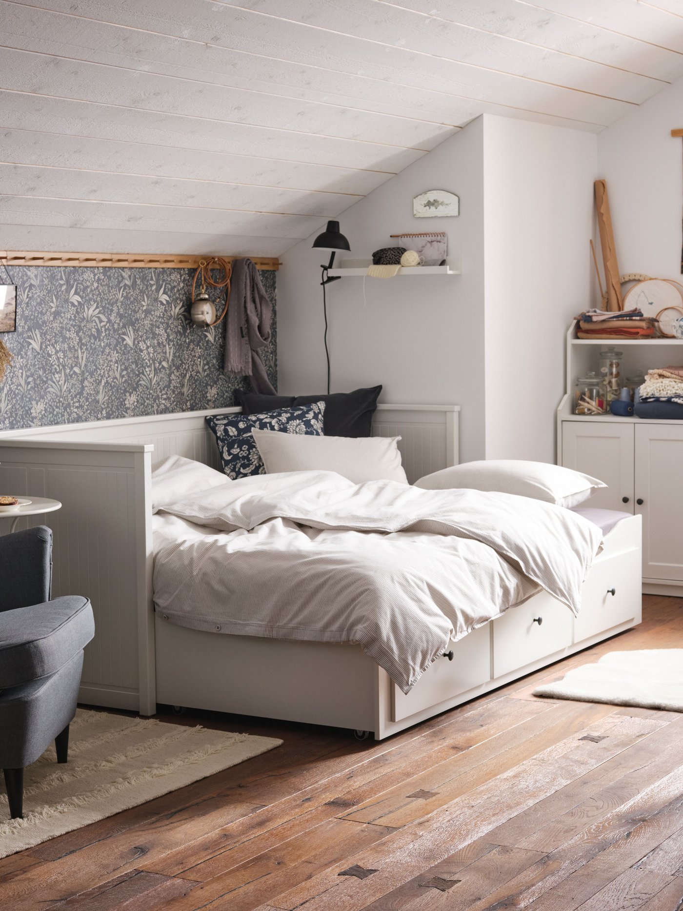 Ein HEMNES Tagesbett ist in einem Zimmer unter einer Dachschräge zu sehen.