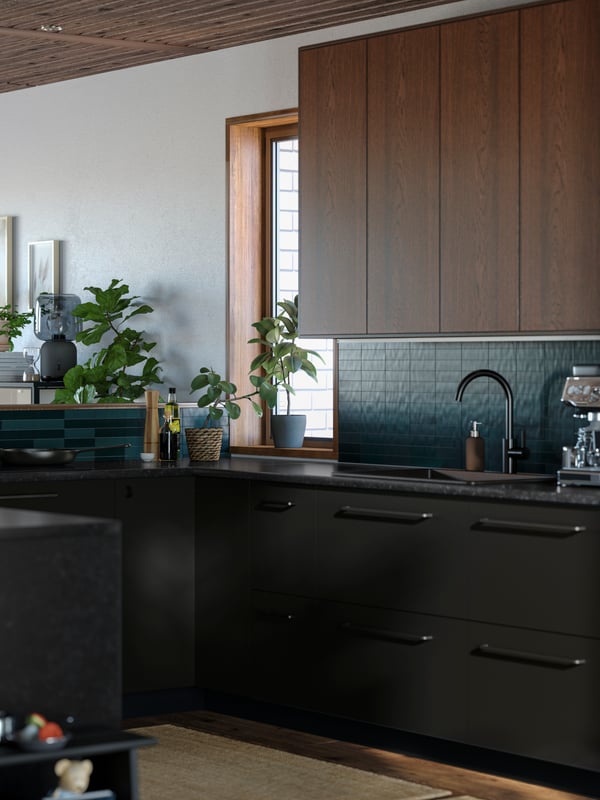 A U-shaped kitchen with wooden floors and ceiling, white walls, green tiles, and kitchen fronts in brown and matt anthracite.