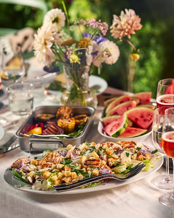 En somrig midsommarbuffé med grillat, vattenmelon och en somrig sallad.