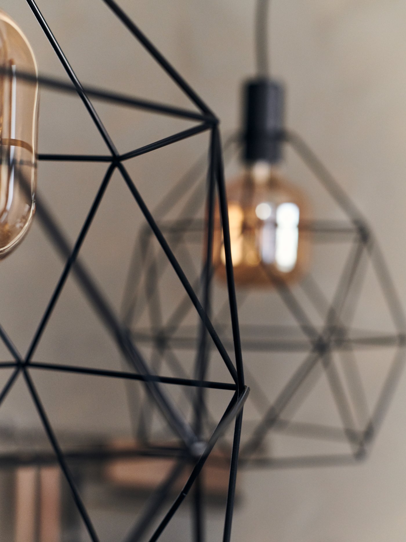 A close-up of a BRUNSTA pendant lamp with another BRUNSTA pendant lamp in the background.