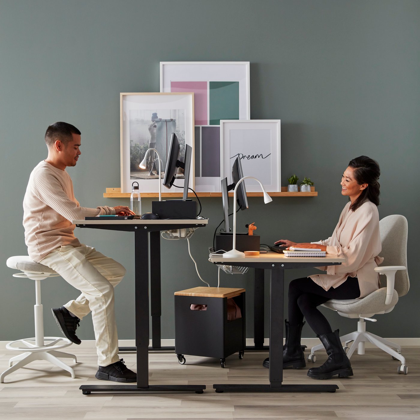 Two people are working at a TROTTEN desk sit/stand in a home office.