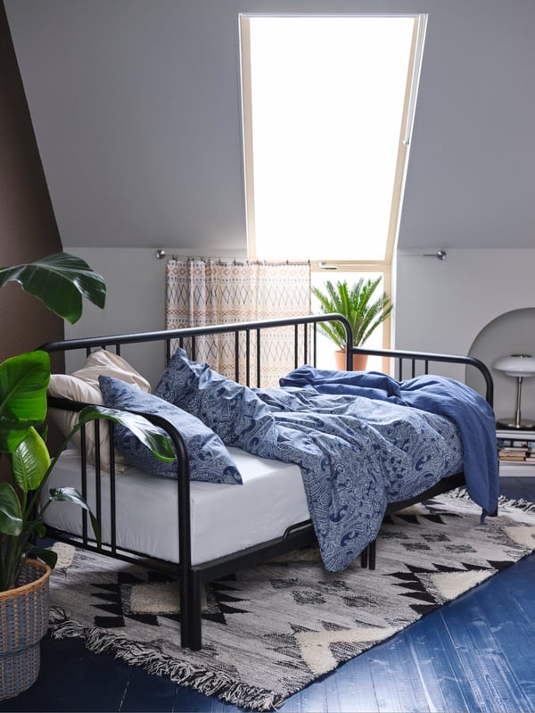 A black FYRESDAL day-bed frame in the bedroom