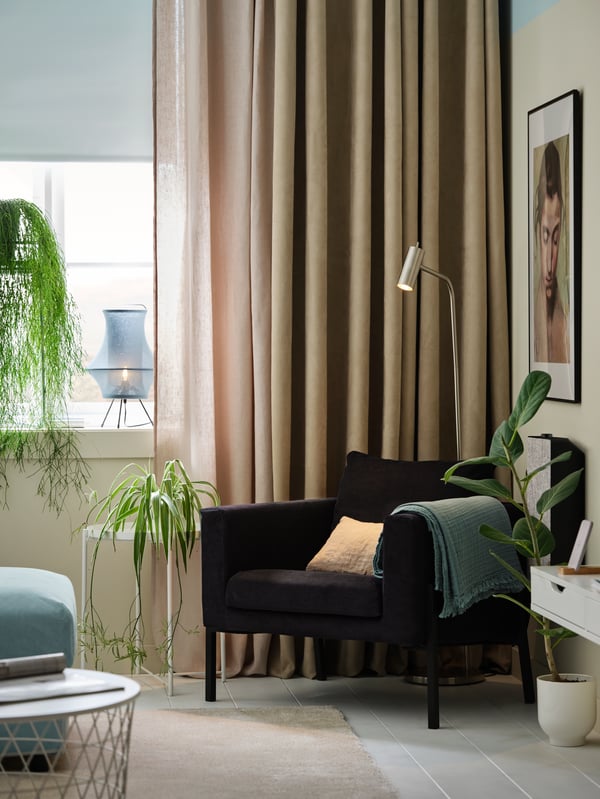 A room with three layers of window coverings. A FRIDANS roller blind, a DYTÅG curtain, and a BIRTNA curtain.