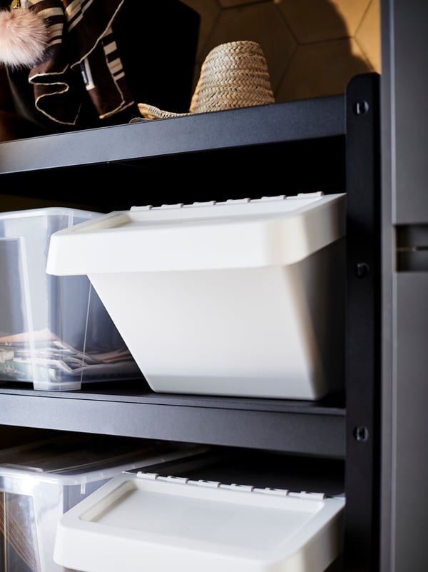 Inside an open garage, a large black BROR shelving unit is stacked with numerous different sized boxes and containers.