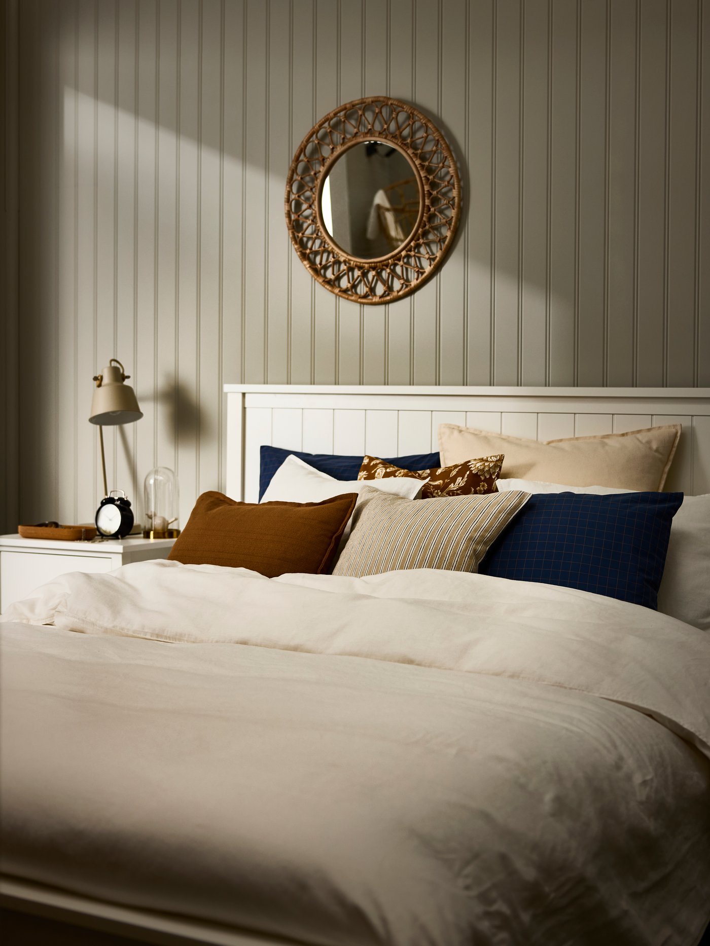A white bed with beige bett linen.