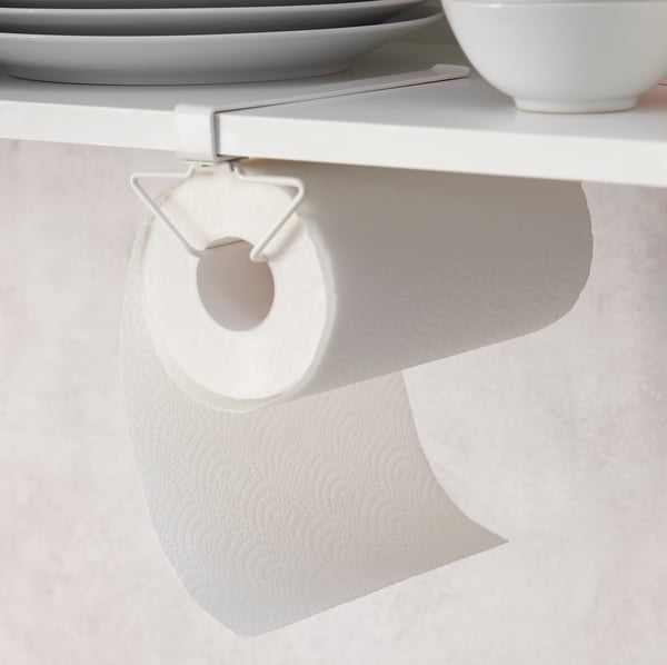 A PÅLYCKE multi-purpose clip-on rack attached to shelving holding a kitchen paper roll, various plates and cups on the shelf.