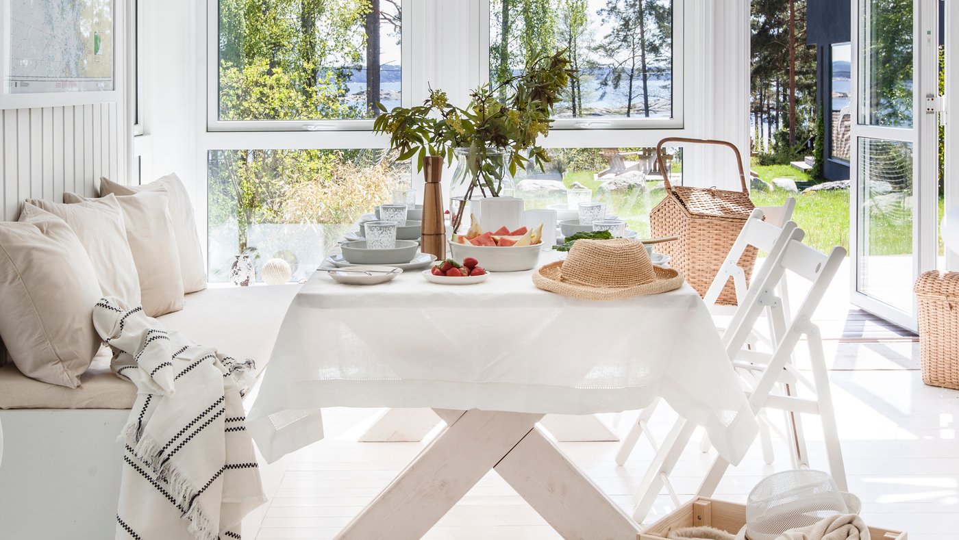 Et flot dækket bord med udsigt til havet i et lyst sommerhus.